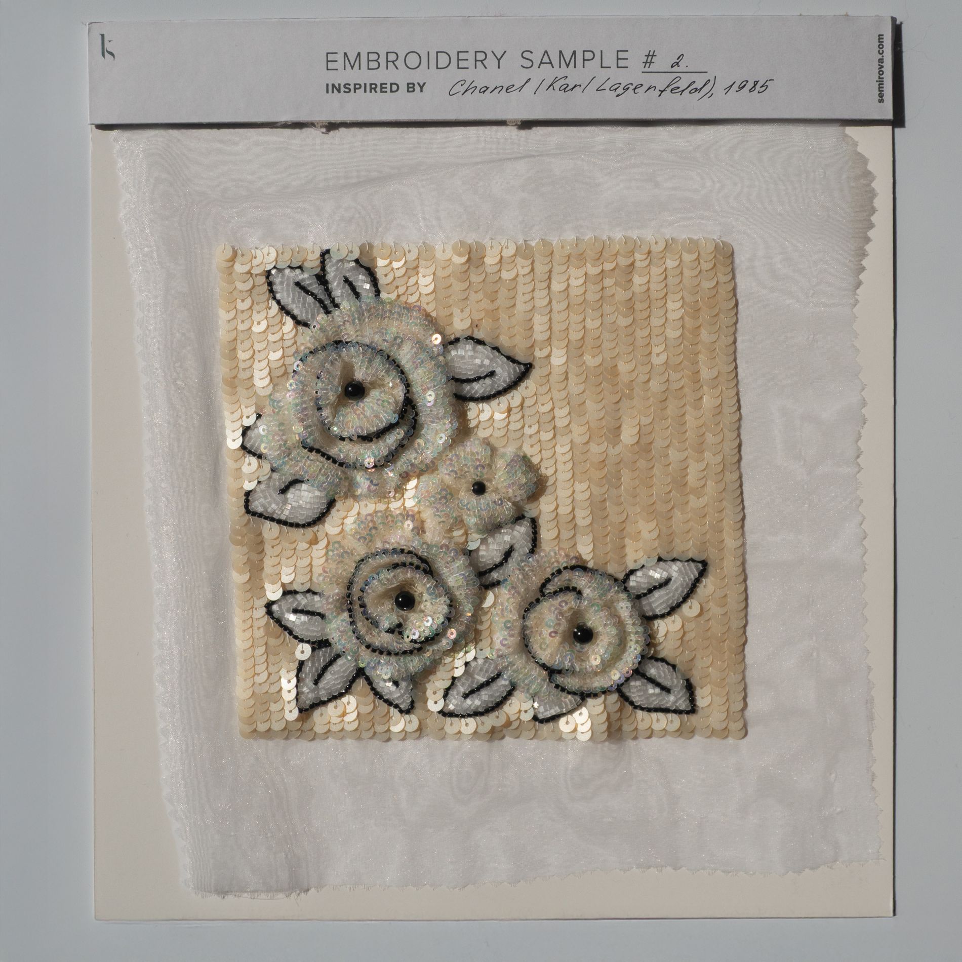 Chanel 1985 Luneville Couture Embroidery Study Sample Luneville couture embroidery sample inspired by a 1985 Chanel design, featuring an ivory sequin ground, layered circular floral motifs, black stitched outlines, and hand-worked sequin detailing.