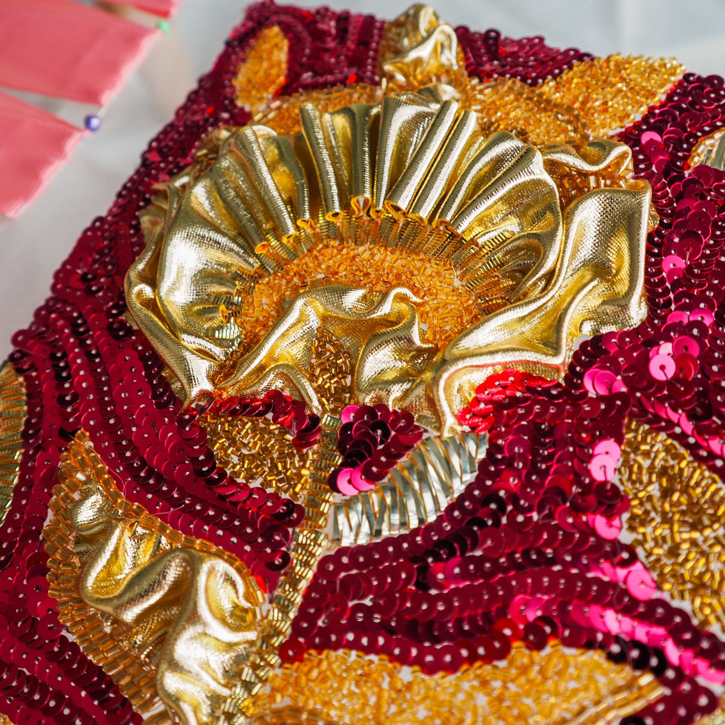 Dior 1986–1987 Marc Bohan Couture Embroidery Study – Detail Close-up of a couture embroidery sample inspired by Dior Autumn–Winter 1986–1987 by Marc Bohan, showing sculpted gold fabric with red and gold sequin and bead embroidery.