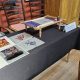 Table display by Ksenia Semirova showing a Luneville embroidery frame with work in progress, threads, and multiple couture-inspired embroidery samples at the Society of Designer Craftsmen group meeting, May 2025.