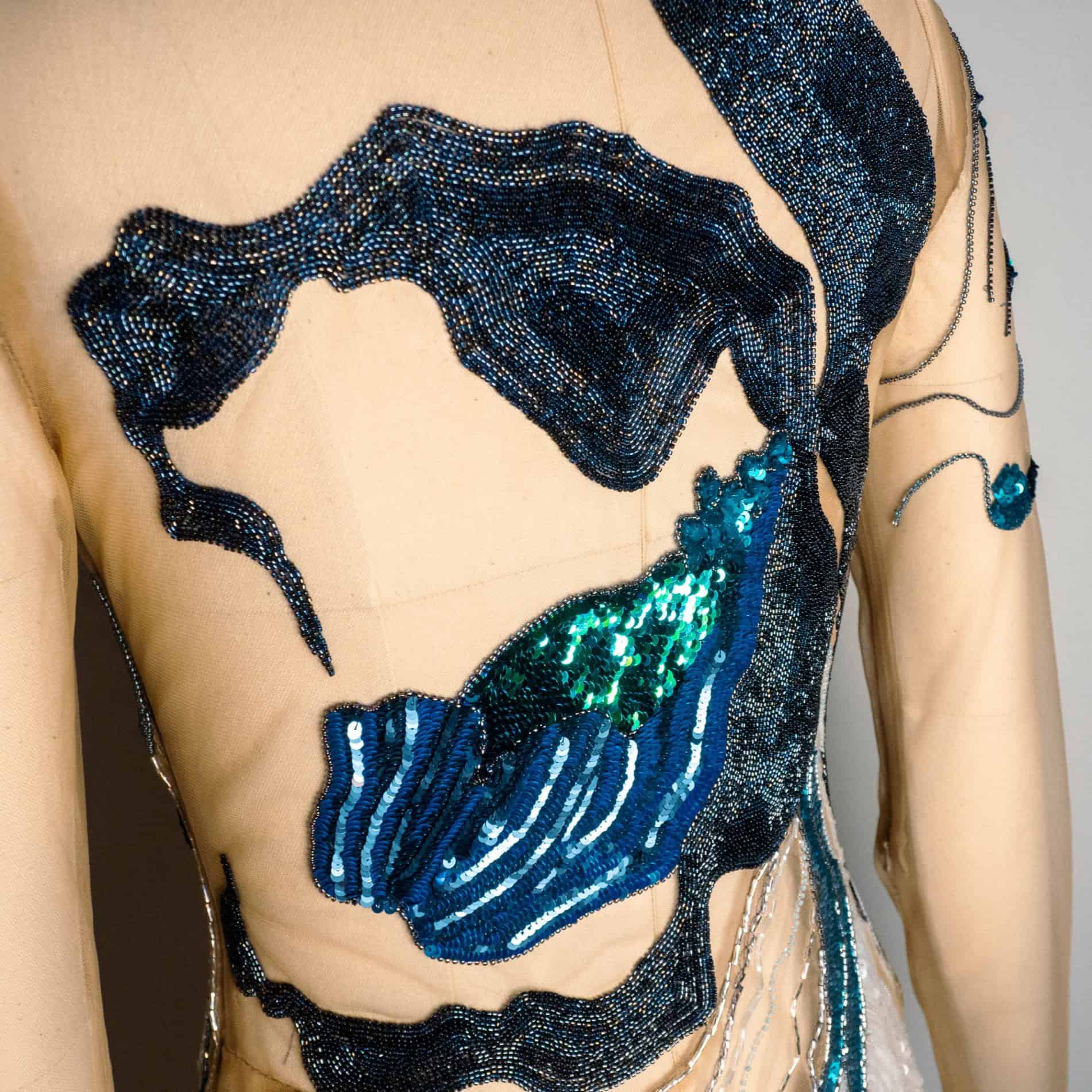 Lady Slipper Couture Dress – Back Embroidery Close-Up Close-up of blue and black Luneville embroidery across the back of the Lady Slipper couture dress.