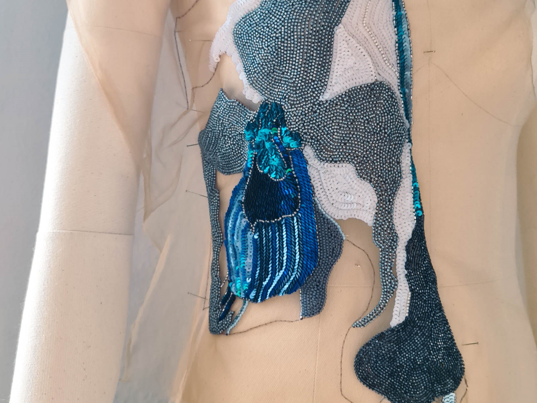 Lady Slipper Couture Dress – Luneville Embroidery in Progress Luneville embroidery in progress on the Lady Slipper couture dress, showing a blue orchid motif on sheer fabric.