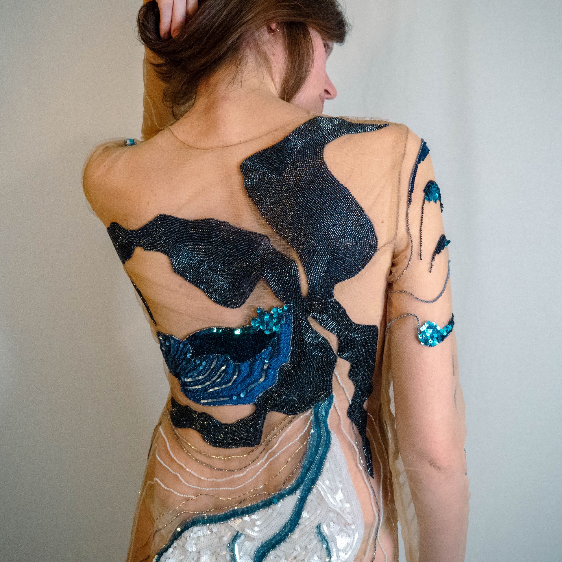 Lady Slipper Dress – Luneville Embroidery Back Detail Closer back view of the Lady Slipper couture dress with large blue and black Luneville embroidered motifs.