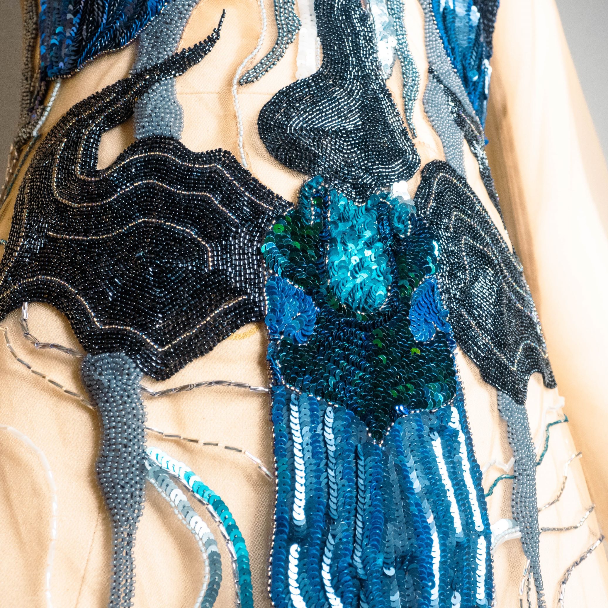 Lady Slipper Dress – Luneville Embroidery Close-Up Close-up of blue, black and grey Luneville embroidery on the sheer Lady Slipper couture dress.