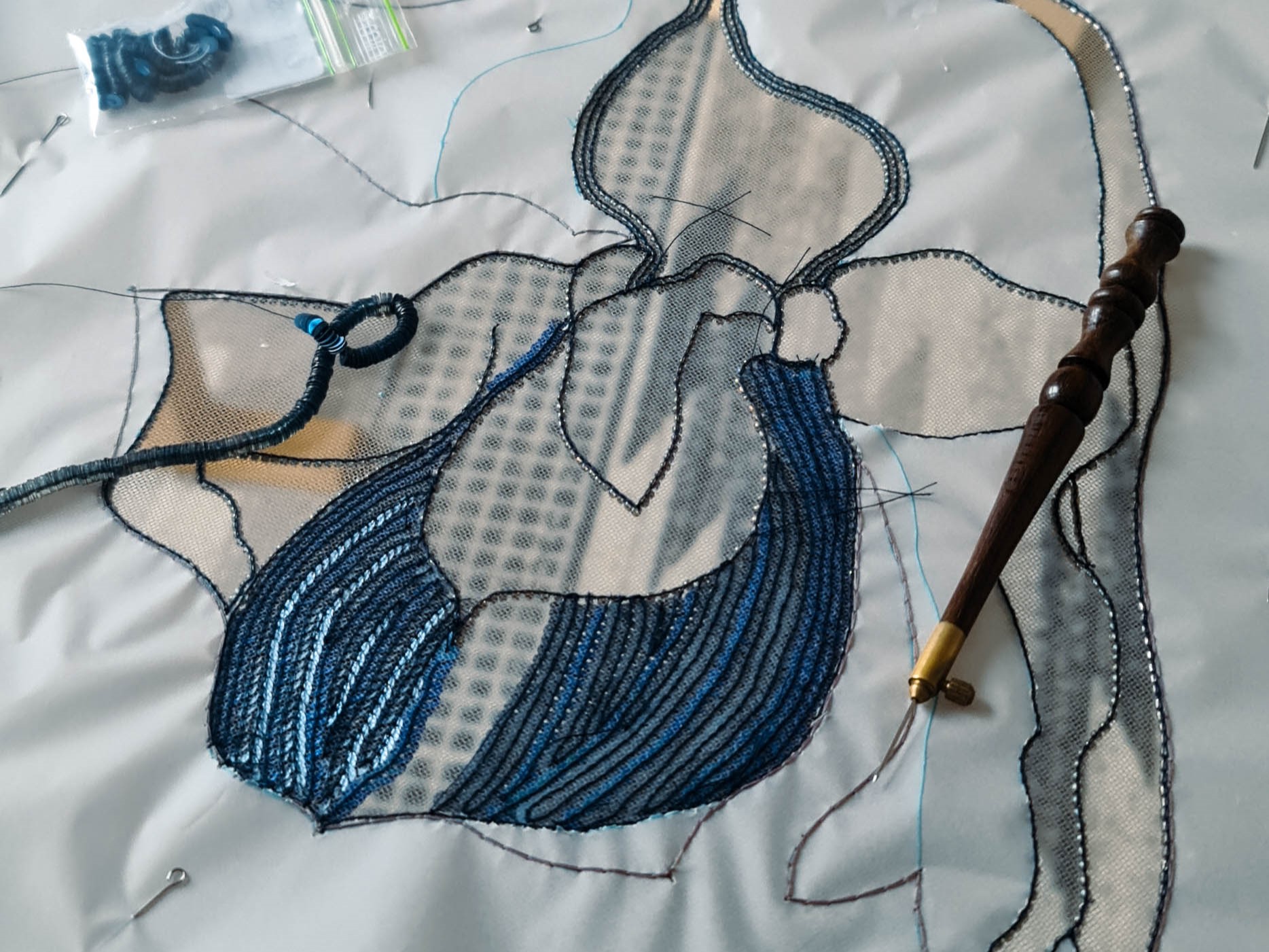 Lady Slipper Dress – Luneville Embroidery Process Luneville embroidery in progress for the Lady Slipper couture dress, with orchid motifs worked onto sheer fabric.
