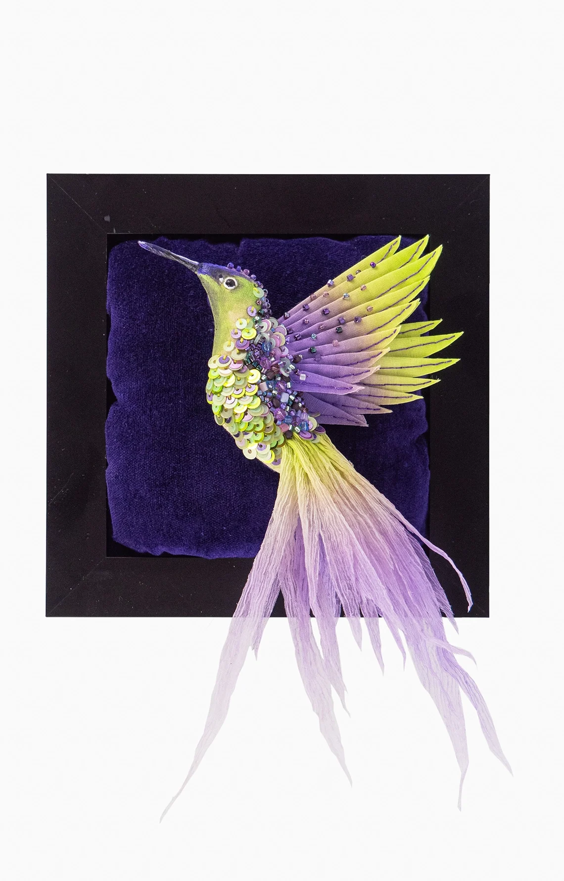 Flying Hummingbird Lime Green and Purple Textile Wall Art and Brooch – 3D embroidered hummingbird handcrafted in lime green and purple silk, adorned with beads and sequins, detachable as a wearable brooch, displayed on a deep velvet background