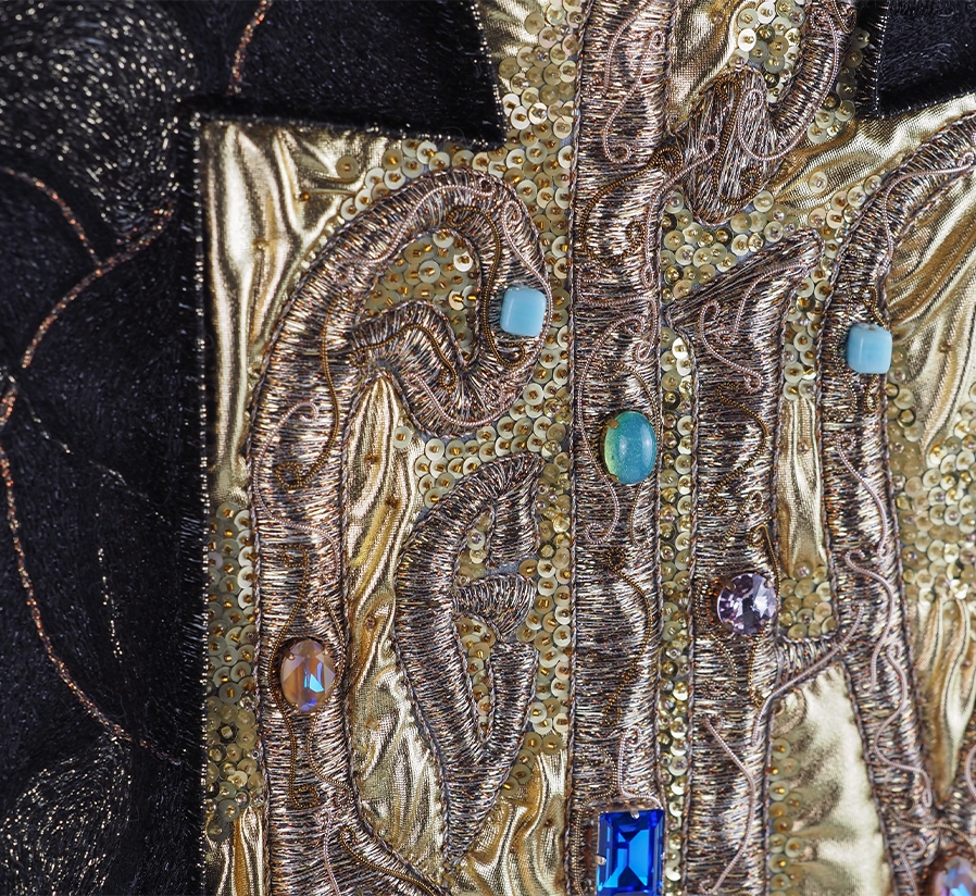 Believe – Detail of Goldwork Vyaz Embroidery by Ksenia Semirova | Ksenia Semirova. Embroidery art Close-up of Believe embroidery by Ksenia Semirova, showing Vyaz calligraphy stitched with gold thread and bead embellishment over dark textile.