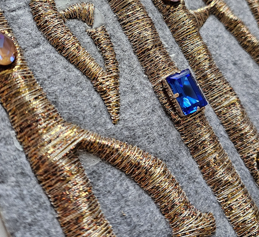Believe – Goldwork Embroidery Progress Detail with Crystals | Ksenia Semirova. Embroidery art In-progress detail of Believe showing gold embroidery with embedded crystals and cords outlining Vyaz lettering by Ksenia Semirova.