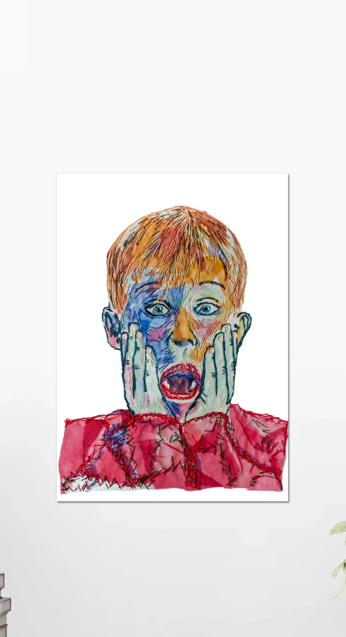 Home Alone Kevin embroidery art poster featuring a vibrant, colorful abstract portrayal of Kevin's iconic shocked expression, displayed on a white wall above a wooden table with minimalist decor | Christmas Movie Wall Art Print