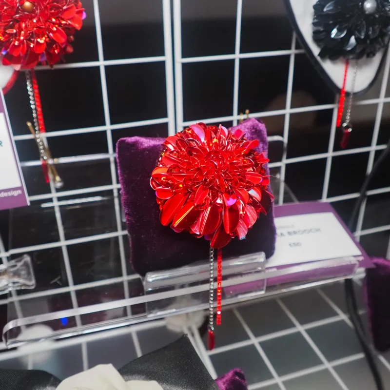 "Limited Edition Red Dahlia Brooch featuring hand-embroidered red sequins and beads, with a blood drop bead and rhinestone chain for a gothic fashion accessory