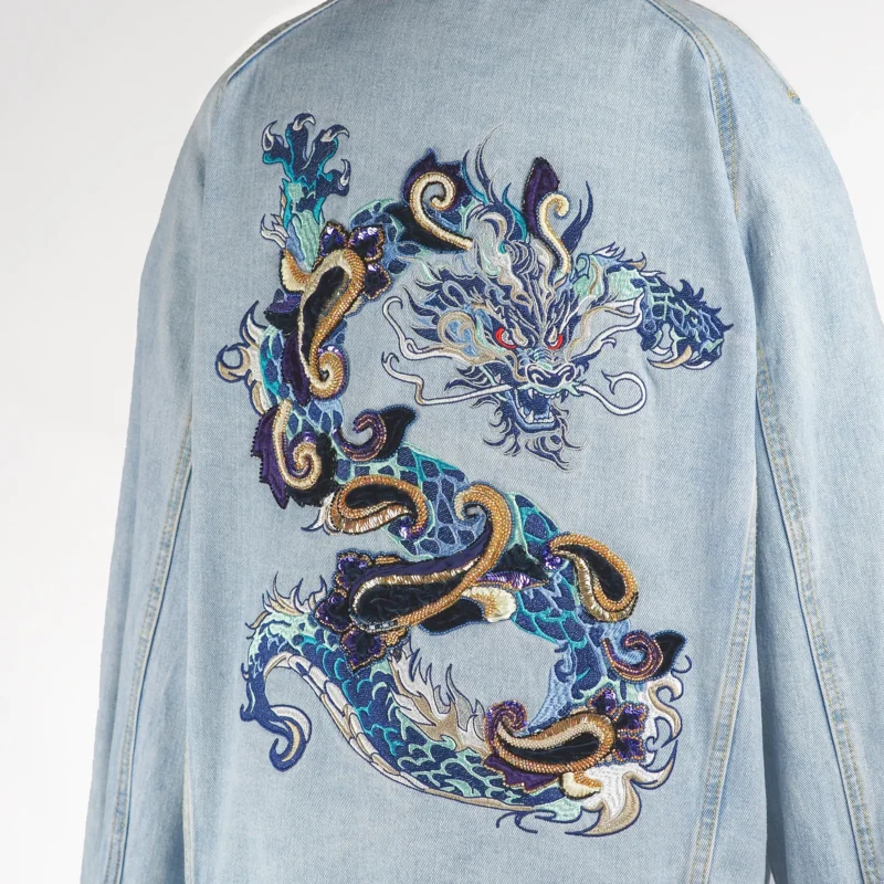 Close-up of Hand-embroidered dragon denim jacket with velvet, beads, and vintage sequins