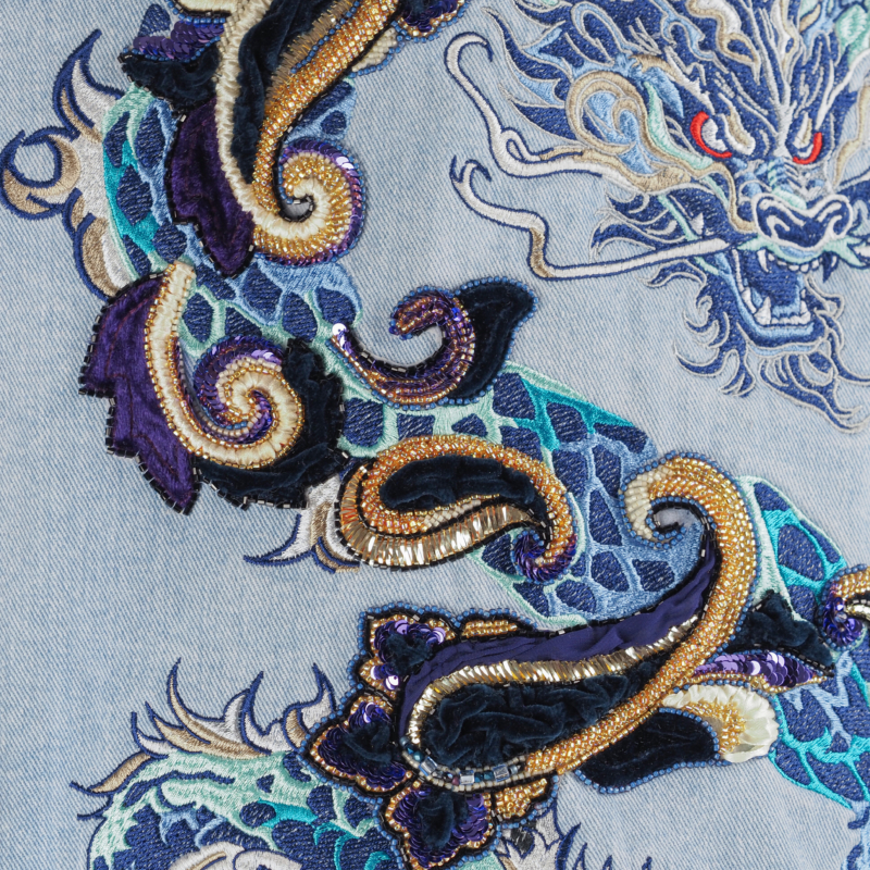 Close-up of Hand-embroidered dragon denim jacket with velvet, beads, and vintage sequins