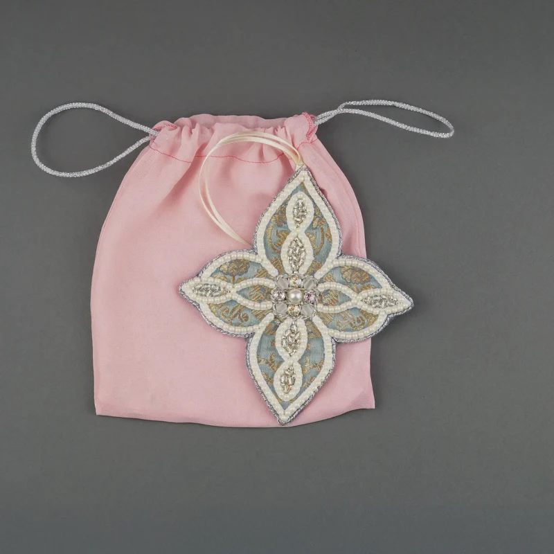 Star-shaped ornament from the Jewels of Winter series, crafted with pearl and bead embroidery, displayed with a handmade pink bag designed to safely store the Christmas decoration