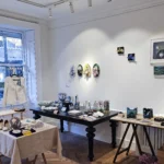 rtisan works displayed at SoShiro Gallery, including pearl embroidery designs, framed art, textiles, and handcrafted items on tables and walls