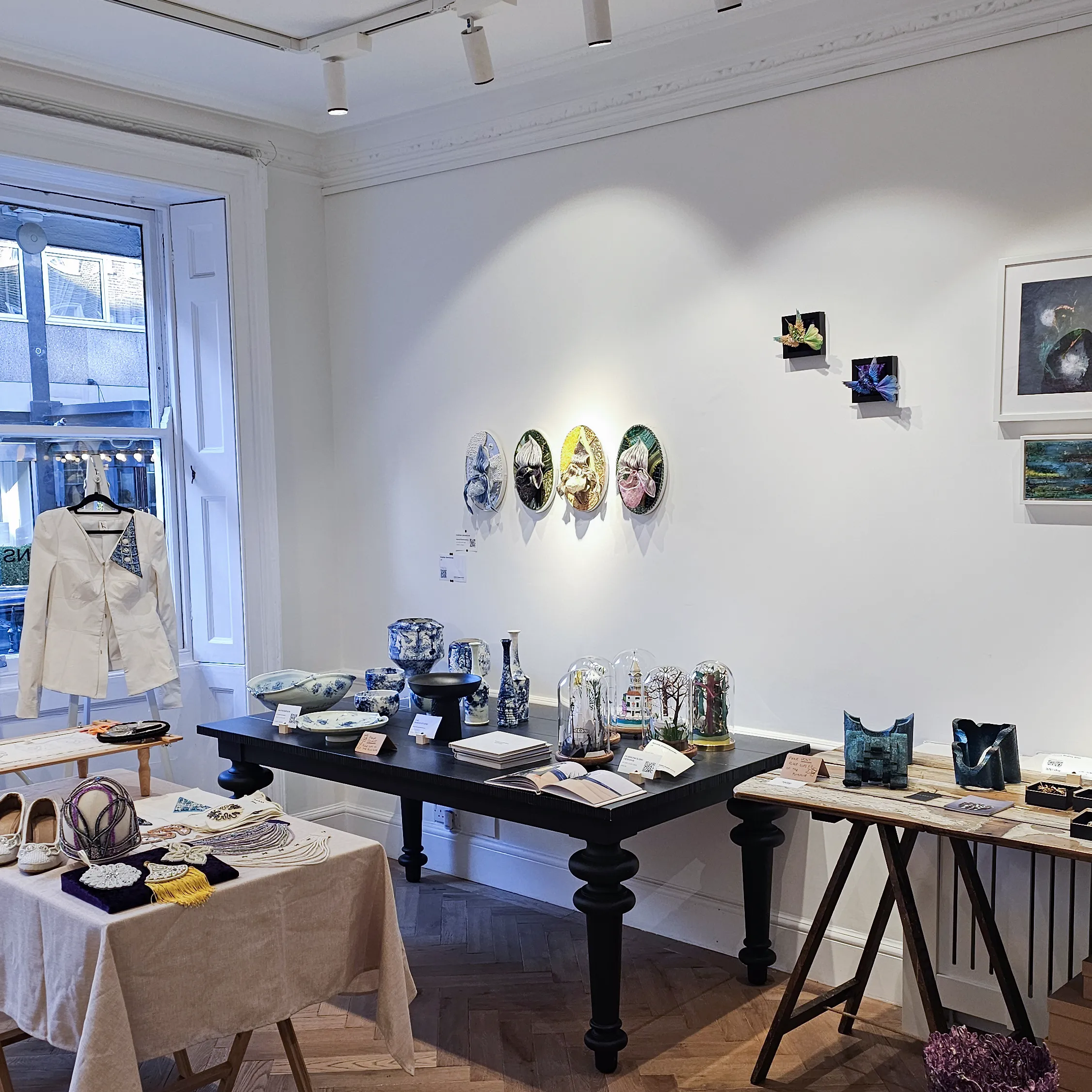 Pearl Embroidery Demonstration at SoShiro Gallery artisan works displayed at SoShiro Gallery, including pearl embroidery designs, framed art, textiles, and handcrafted items on tables and walls