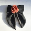 A handmade hair clip featuring a large black chiffon bow measuring approximately 16x25 cm, adorned at the center with a single red silk rose about 6 cm in diameter. The accessory combines bold black and vibrant red colors, showcasing elegant craftsmanship suitable for gothic fashion or evening wear.