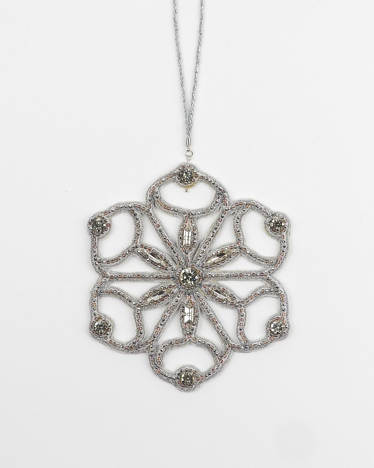 Six-pointed cut-out snowflake ornament by Ksenia Semirova, handcrafted with silver beads and crystals in a lace-like open structure using the pearl-setting technique.