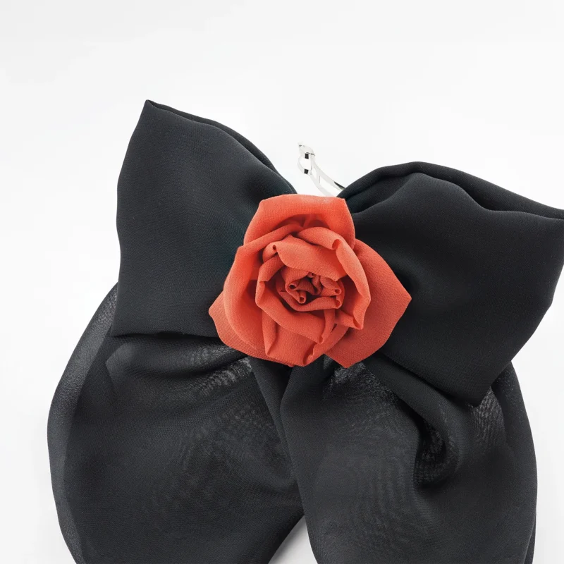 Close-up of a handmade black chiffon bow hair clip featuring a detailed red chiffon rose centerpiece, perfect for elegant hairstyles and statement fashion