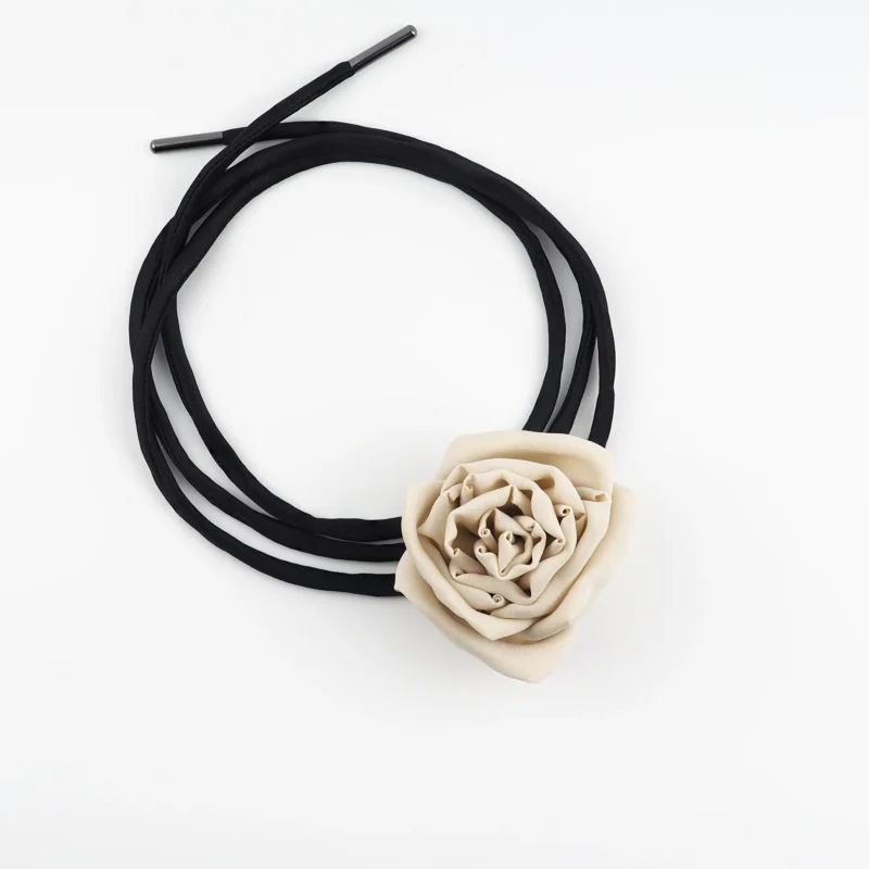 Image of a handmade nude silk rose choker featuring a handcrafted silk rose centerpiece with adjustable black satin lace, perfect for day-to-night styling