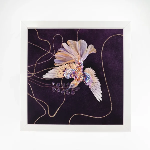 Luxury framed textile artwork featuring a detailed hand-embroidered hummingbird in purple and gold tones. The design includes shimmering sequins and intricate stitching on a deep purple background. Perfect for adding a unique artistic touch to home decor