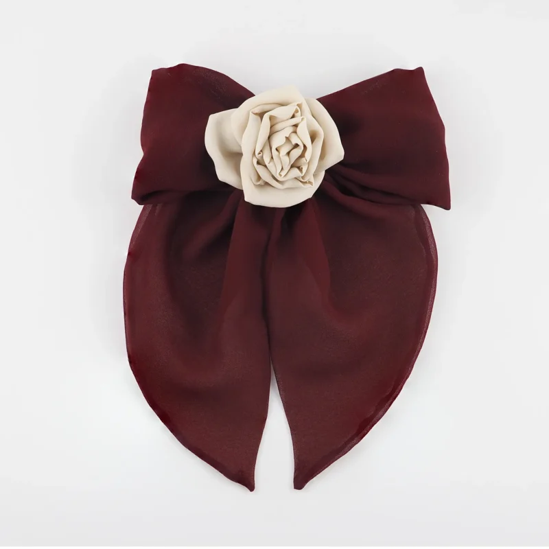 Handmade maroon chiffon bow hair clip with a nude silk rose centerpiece, featuring soft flowing tails and a secure clip design. Perfect for elegant hairstyles, this red bow hair clip adds a sophisticated and handcrafted touch.