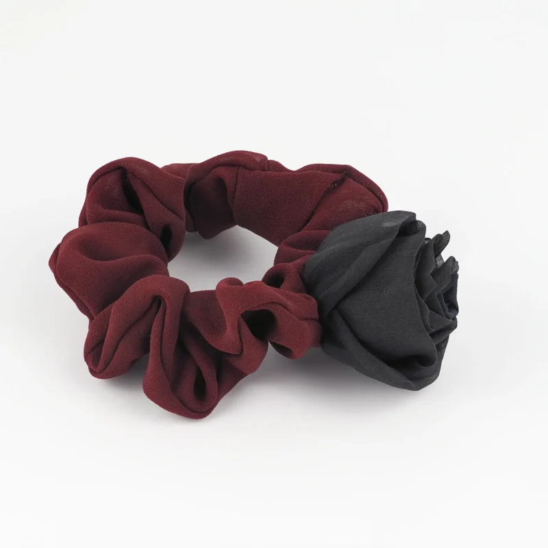 Side view of a handmade chiffon scrunchie with silk rose, featuring a maroon double-layered chiffon band and a bold black silk rose, designed as a luxurious and elegant hair accessory