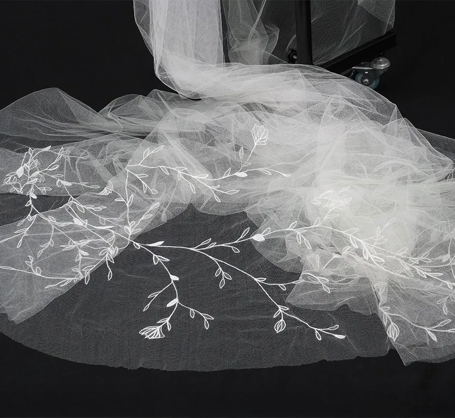 Full view of a bespoke wedding veil laid flat, featuring hand-drawn floral embroidery in tambour lace by Ksenia Semirova.