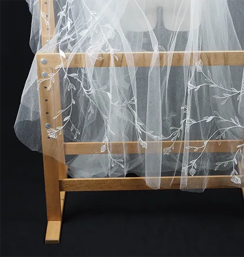 Back and side view of bespoke wedding veil on mannequin, featuring non-repetitive floral embroidery.