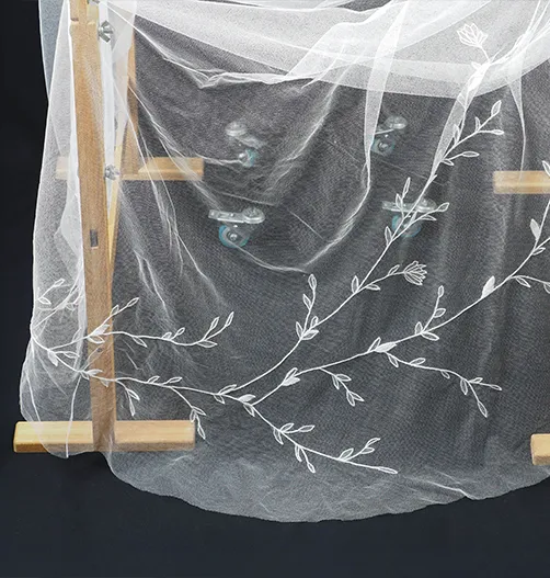 Bespoke wedding veil draped over embroidery stand, showing full floral motif created in tambour lace technique