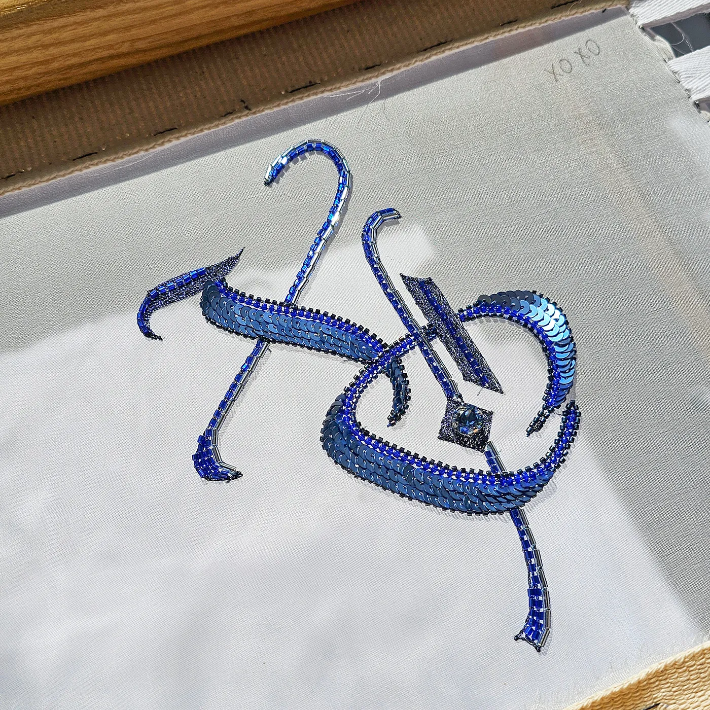XO-Luneville Embroidery for beginners | Ksenia Semirova. Embroidery art Luneville embroidery for beginners – blue sequin XO lettering stitched with tambour hook on silk organza