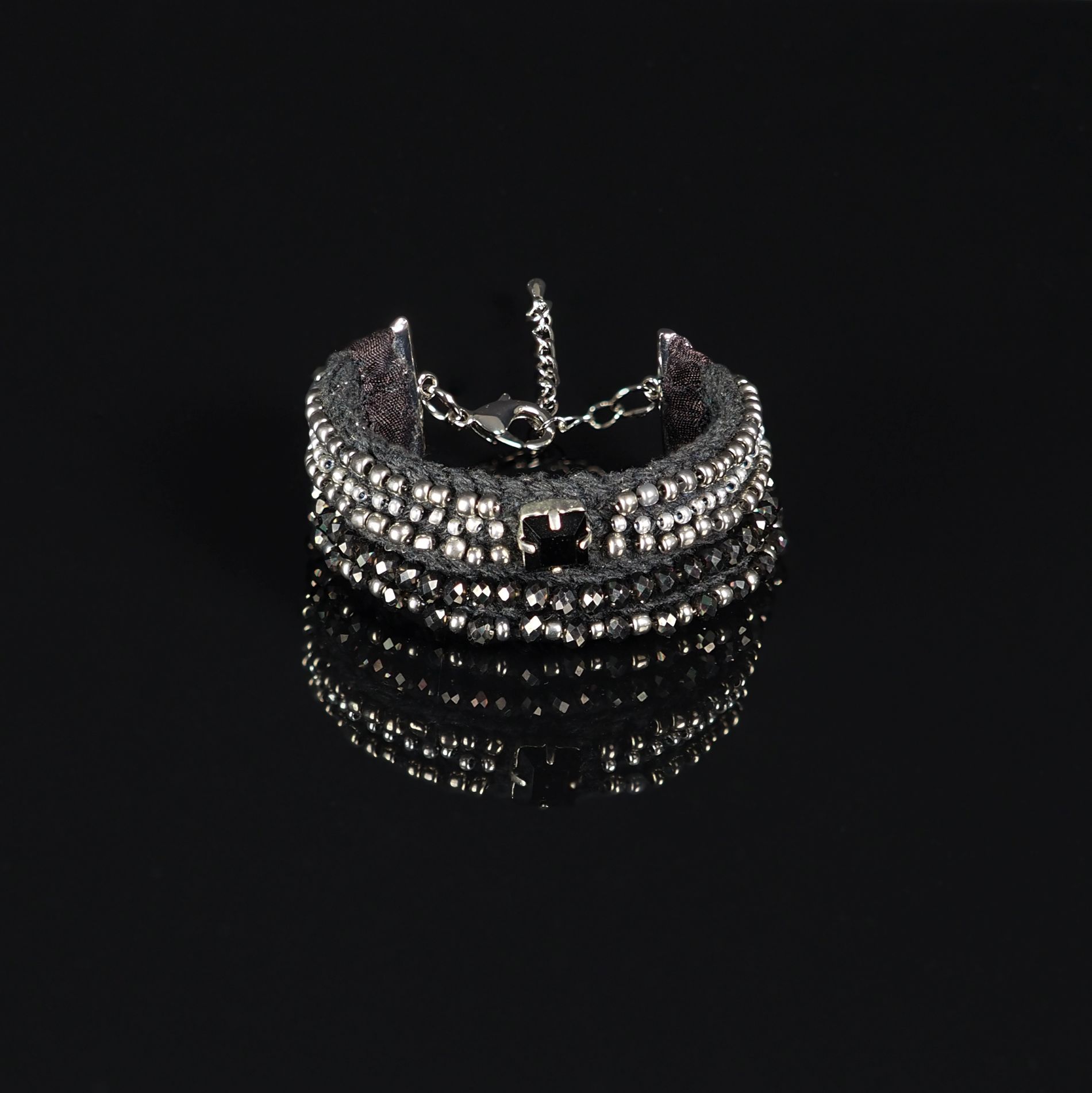 Black Silver Multi-Strand Beaded Bracelet Pearl Setting Example | Ksenia Semirova. Embroidery art Handmade black and silver beaded bracelet with multi-strand design, stitched with the pearl setting embroidery method, on a black reflective surface