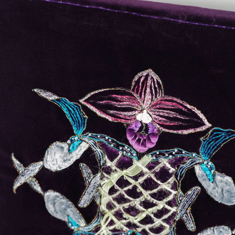 Detailed close-up of abstract orchid embroidery on velvet, showing layered stitching, padded shapes, and beaded accents by Ksenia Semirova