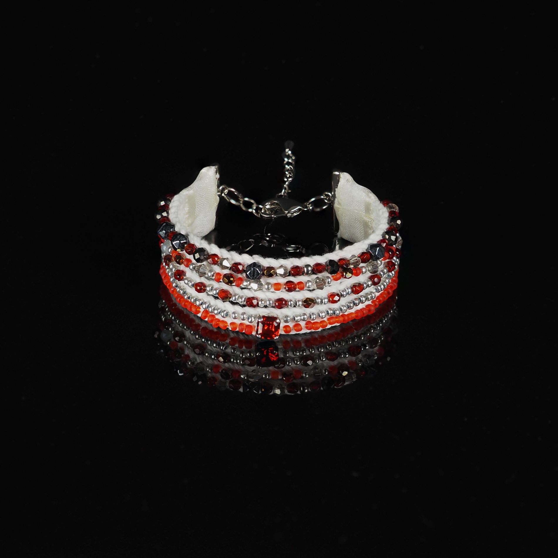 Handmade Multi-Strand Bracelet Red White Black Beadwork | Ksenia Semirova. Embroidery art Multi-strand bracelet in red, white, and black with seed beads and crystals, crafted with pearl setting embroidery, shown on a black reflective surface.