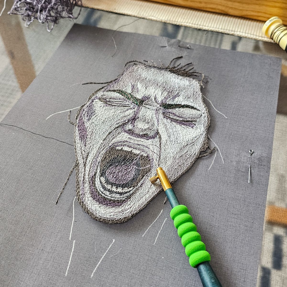 Close-up of screaming face embroidered using tambour technique, part of The Power of No corset by Ksenia Semirova