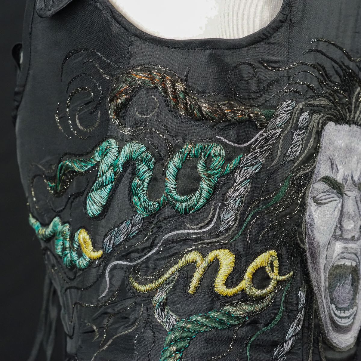 Close-up of left side of corset showing embroidered “No” stitched in yellow and green, integrated into hair-like forms, from The Power of No by Ksenia Semirova