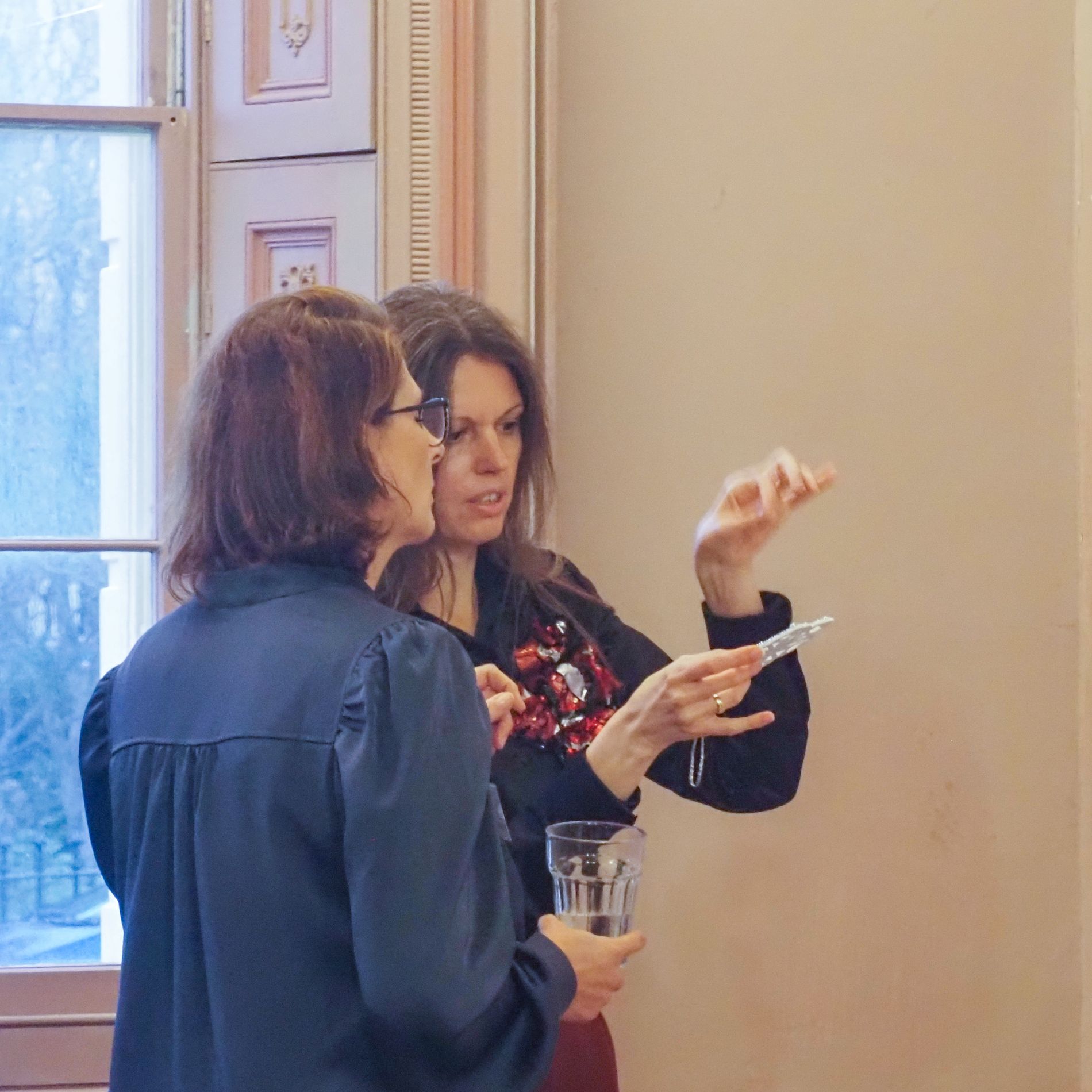 Ksenia Semirova discussing an embroidered piece with a visitor at the Private View in Brighton.
