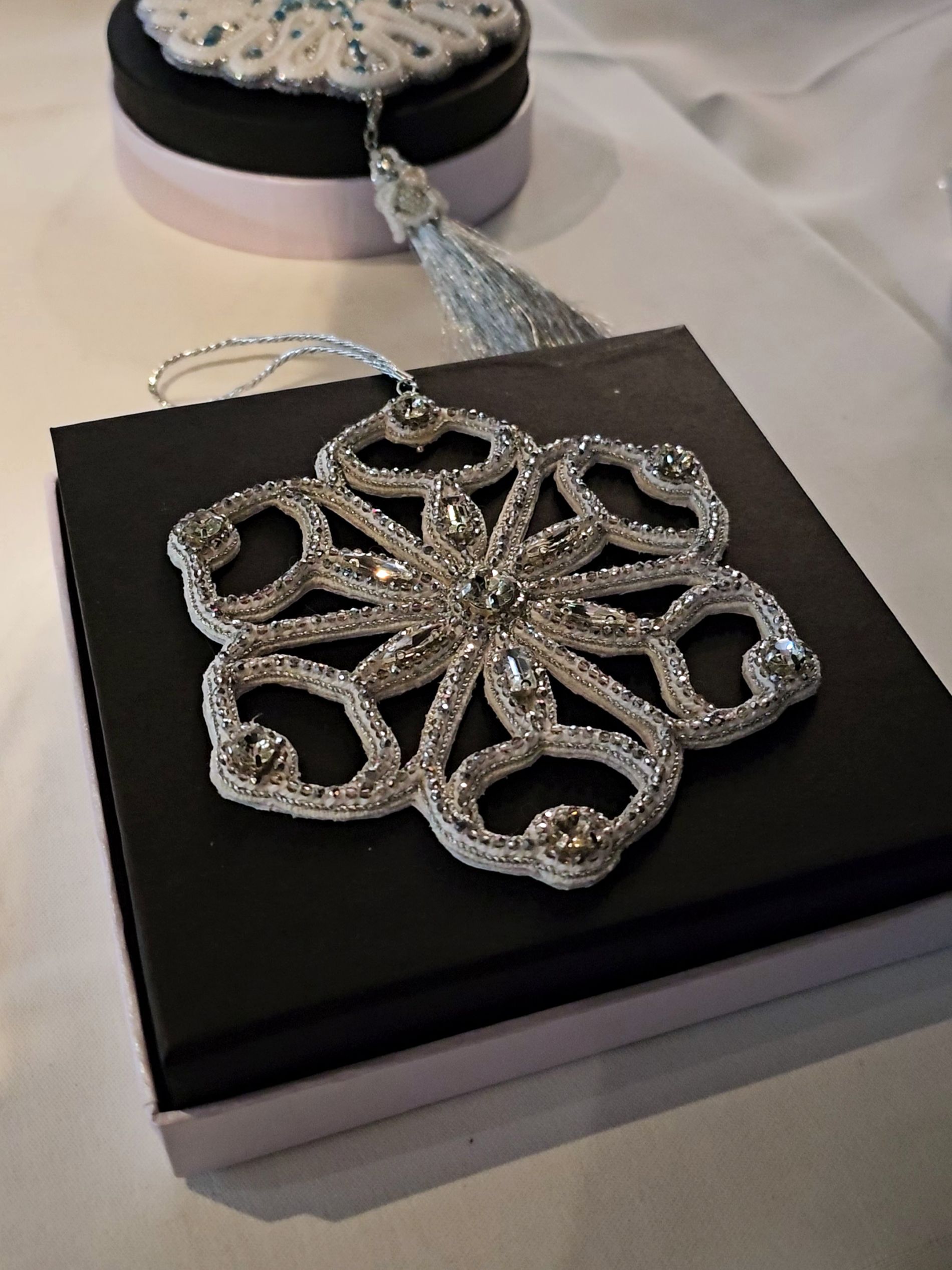 Openwork Crystal Christmas Ornament Openwork Christmas ornament embroidered with silver beads and clear crystals, displayed on a black box