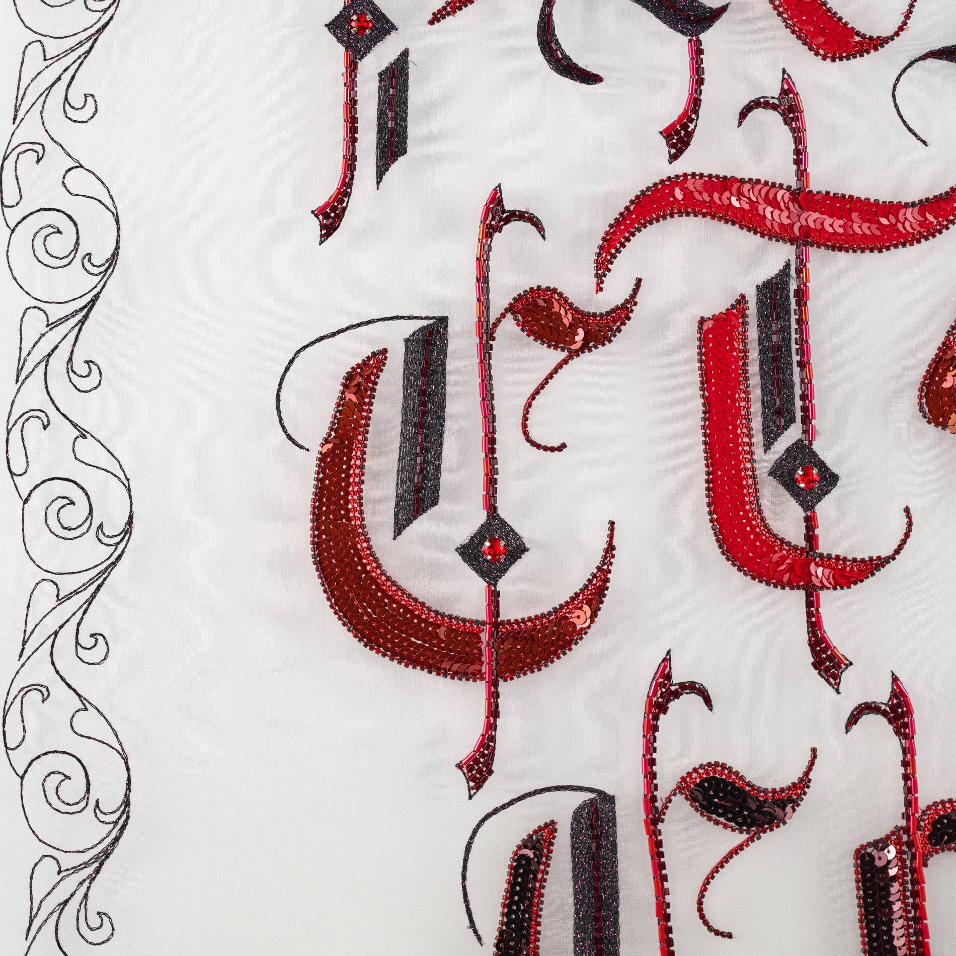 In Practice Central Detail of Gothic Lettering Embroidery Close-up of In Practice showing red and black gothic lettering embroidered with sequins and beads in Luneville embroidery.