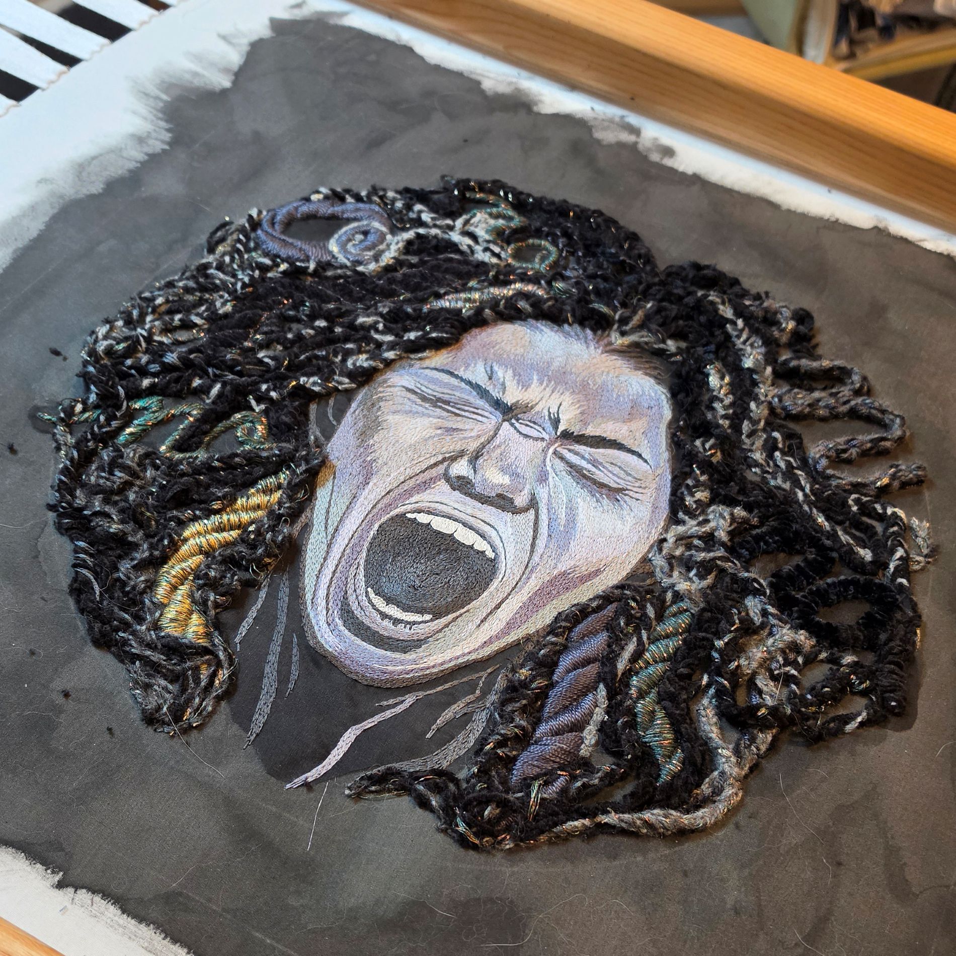 Hand embroidered textile wall art titled Despair from Ksenia Semirova’s Power of No series, showing a stitched portrait with layered black textile details.
