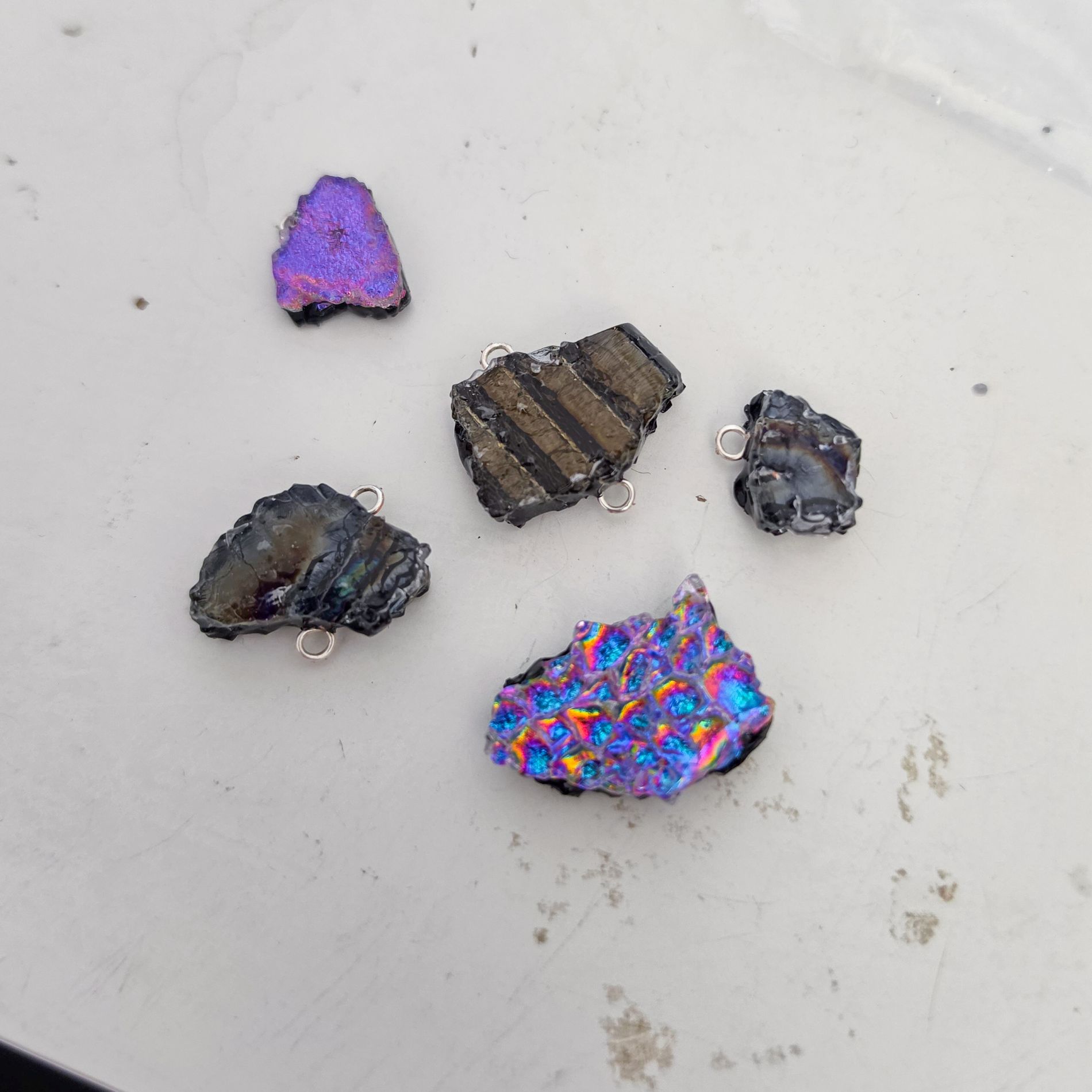 Colourful iridescent handmade glass elements created by Naomi Jacques for the To the Moon and Back necklaces.